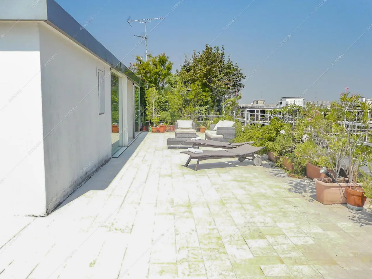 Terrazza con sdraio e divanetti in vimini