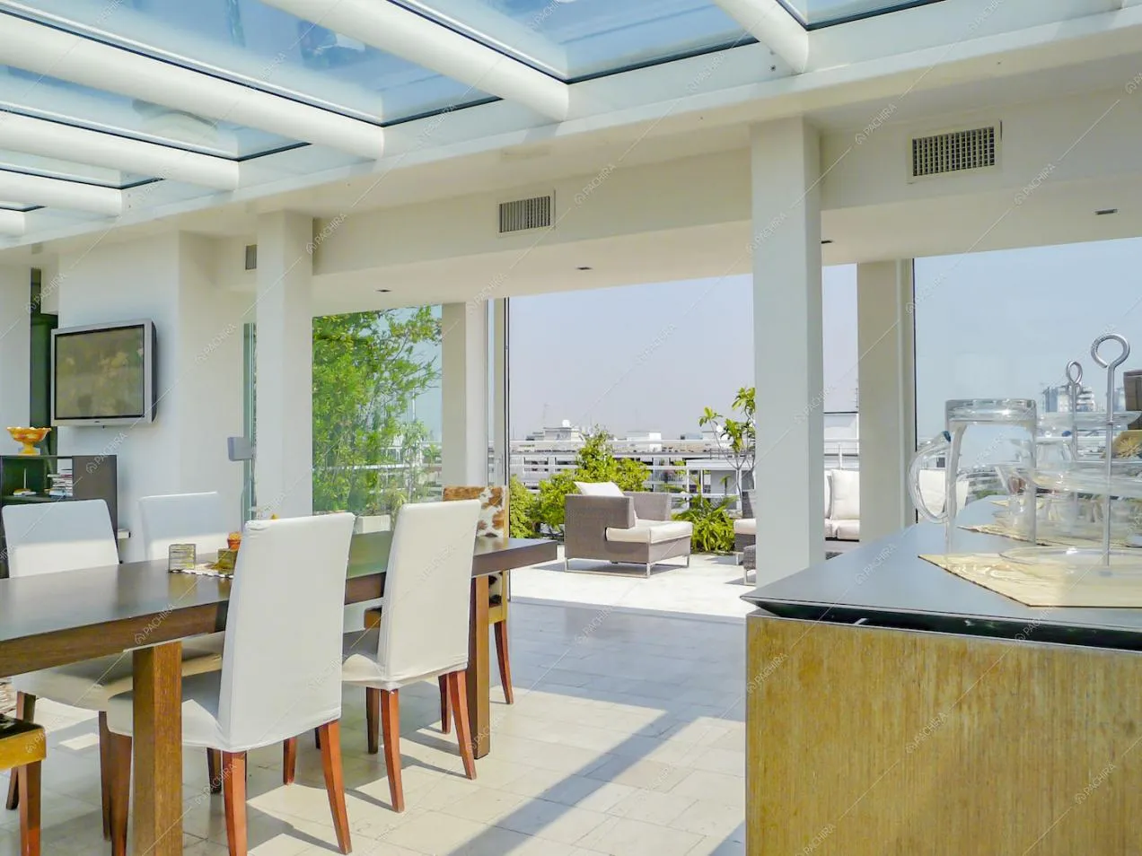 Dall'isola vista su tavolo da pranzo e divanetti esterni