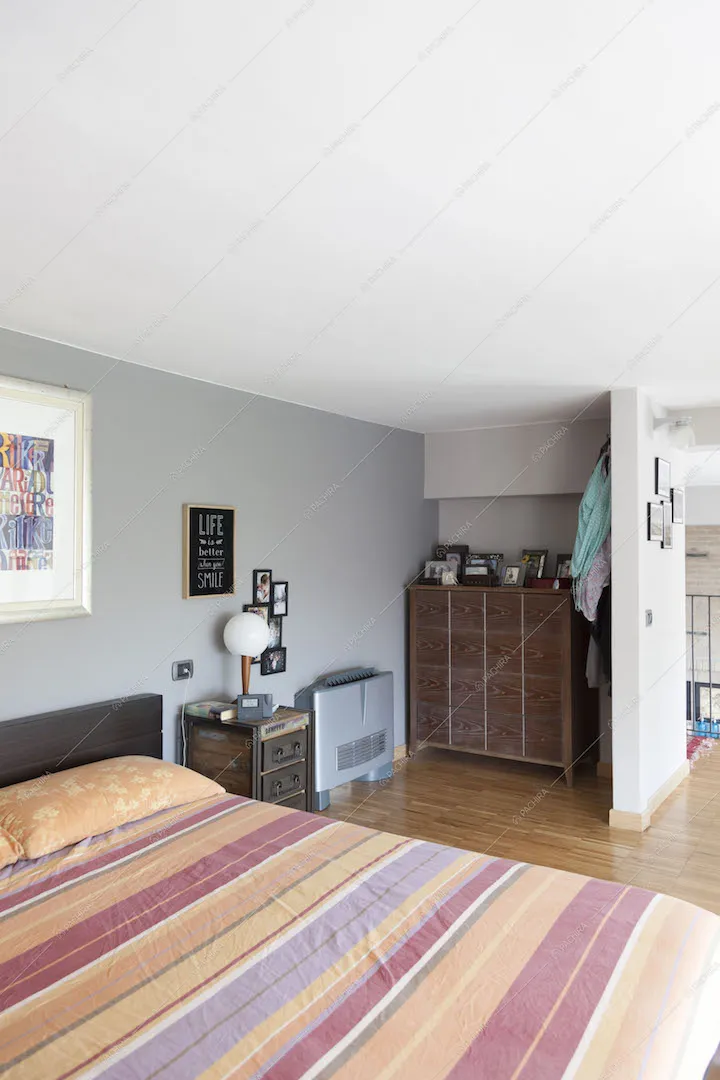 Camera da letto con cassettiera e pavimento in parquet