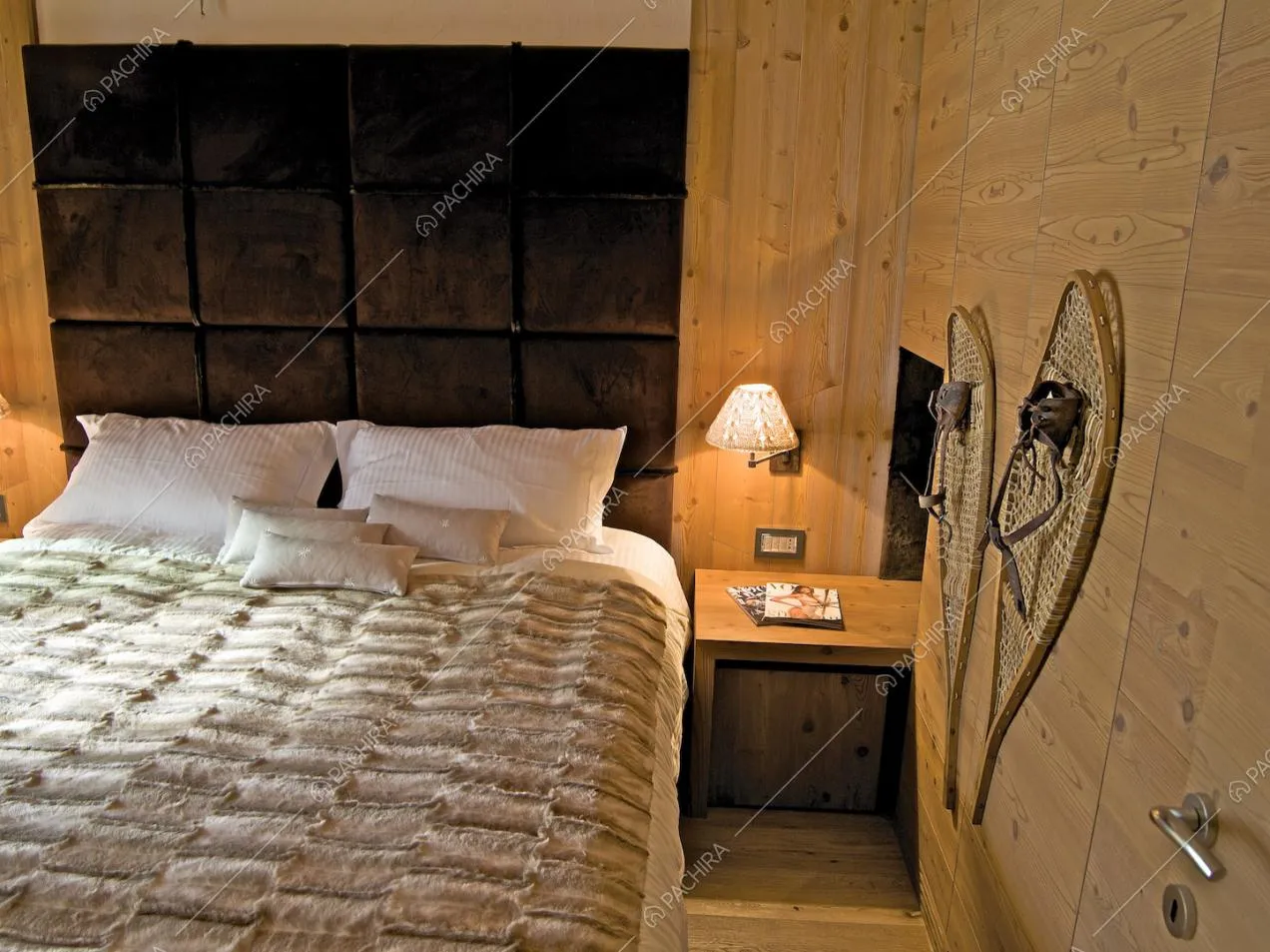 Camera da letto matrimoniale dalle pareti in legno con testa nera in velluto