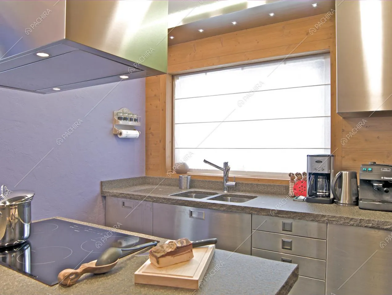 Cucina con isola dalle pareti viola e con fornelli a induzione