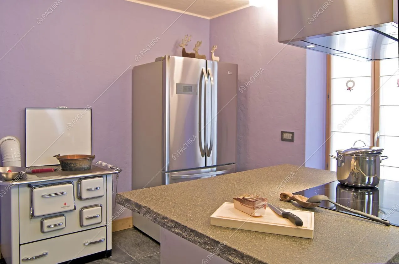 Cucina a isola dalle pareti viola e con fornelli a induzione