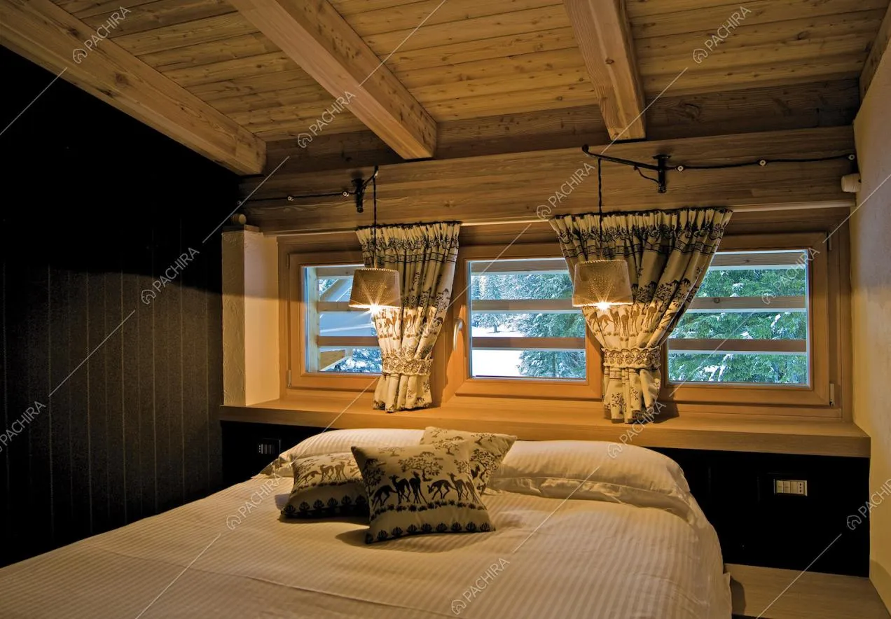 Camera da letto matrimoniale dalle pareti nere e con soffitto in travi in legno a vista