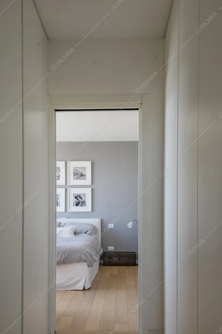 Camera da letto con parete color pastello e parquet