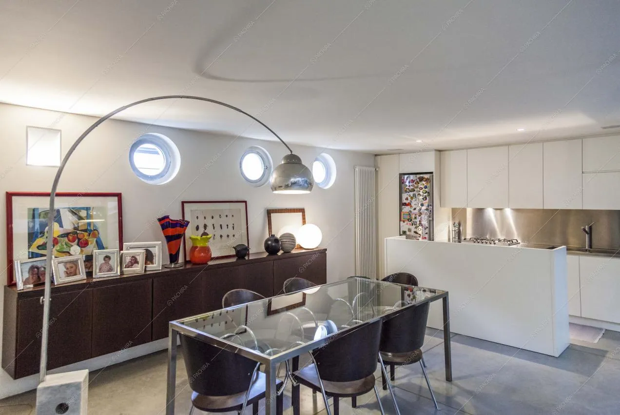 Zona cucina con tavolo da pranzo in vetro e metallo