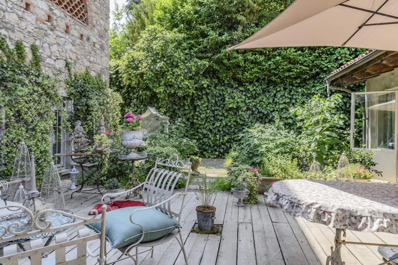 Pavimento in parquet e vista sugli esterni in pietra con rampicanti della villa