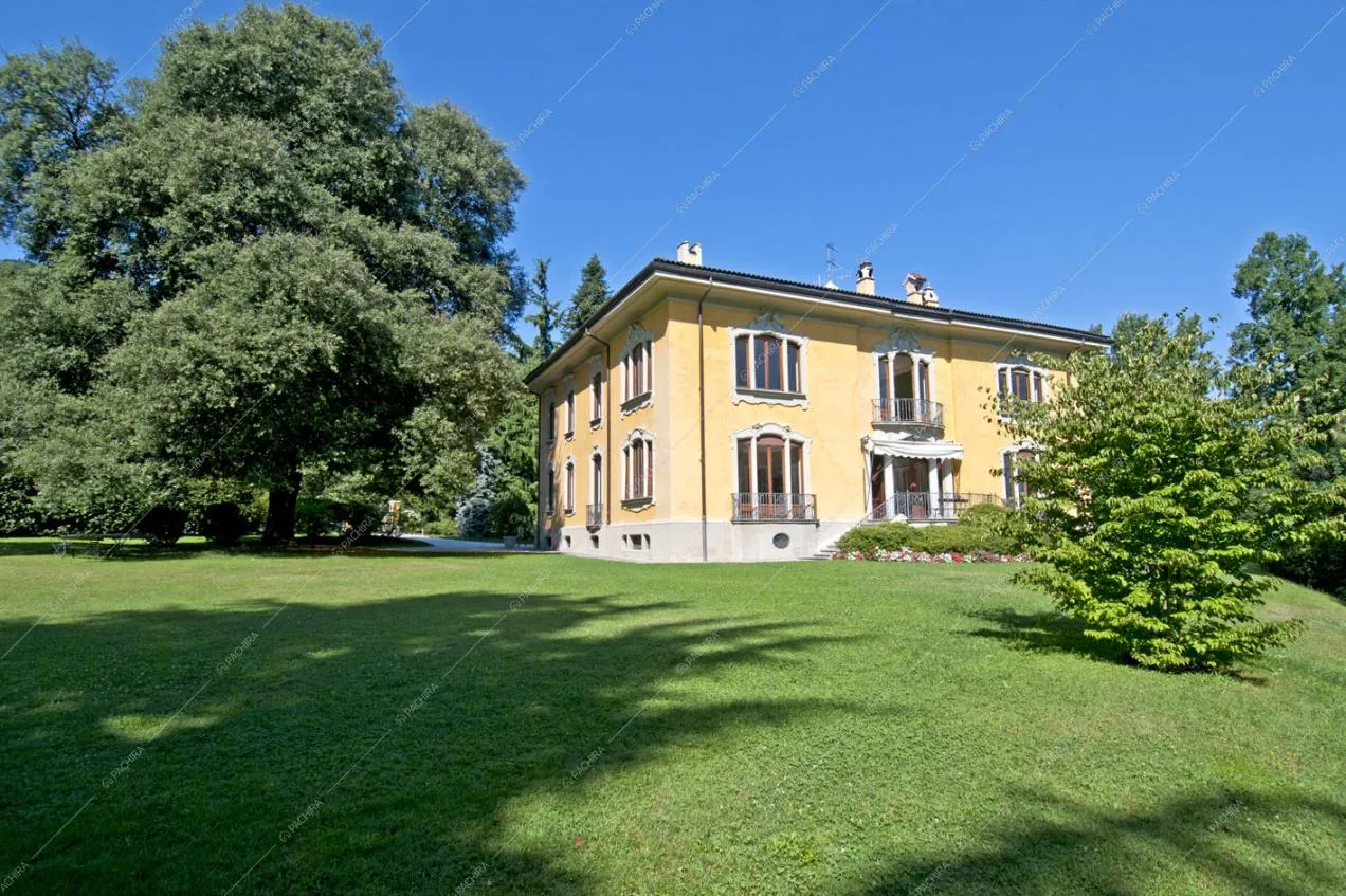 Dal parco della location vista sugli esterni gialli e su alberi sempreverdi