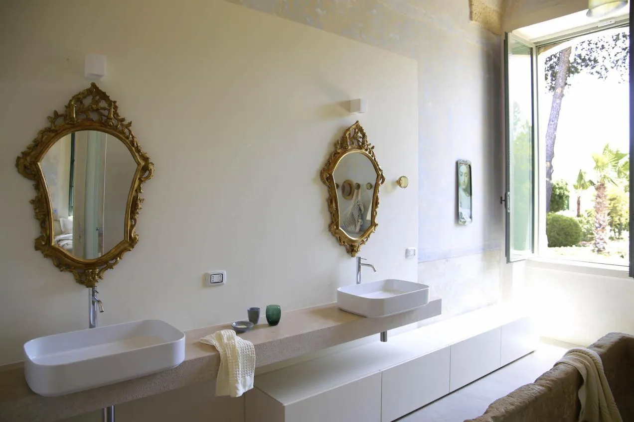Bagno con doppio lavandino e specchi con cornice dorata