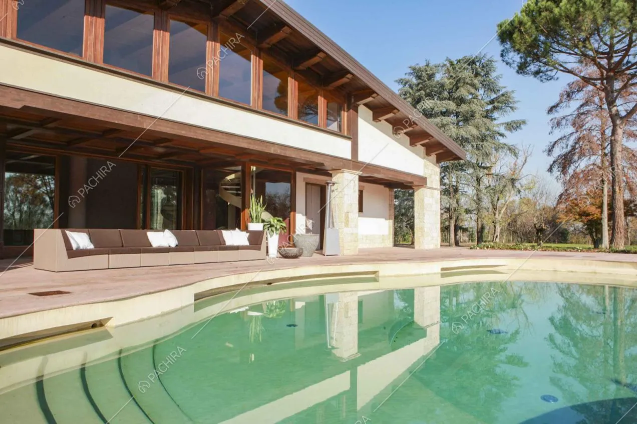 Piscina posta davanti alla veranda con divano da esterno