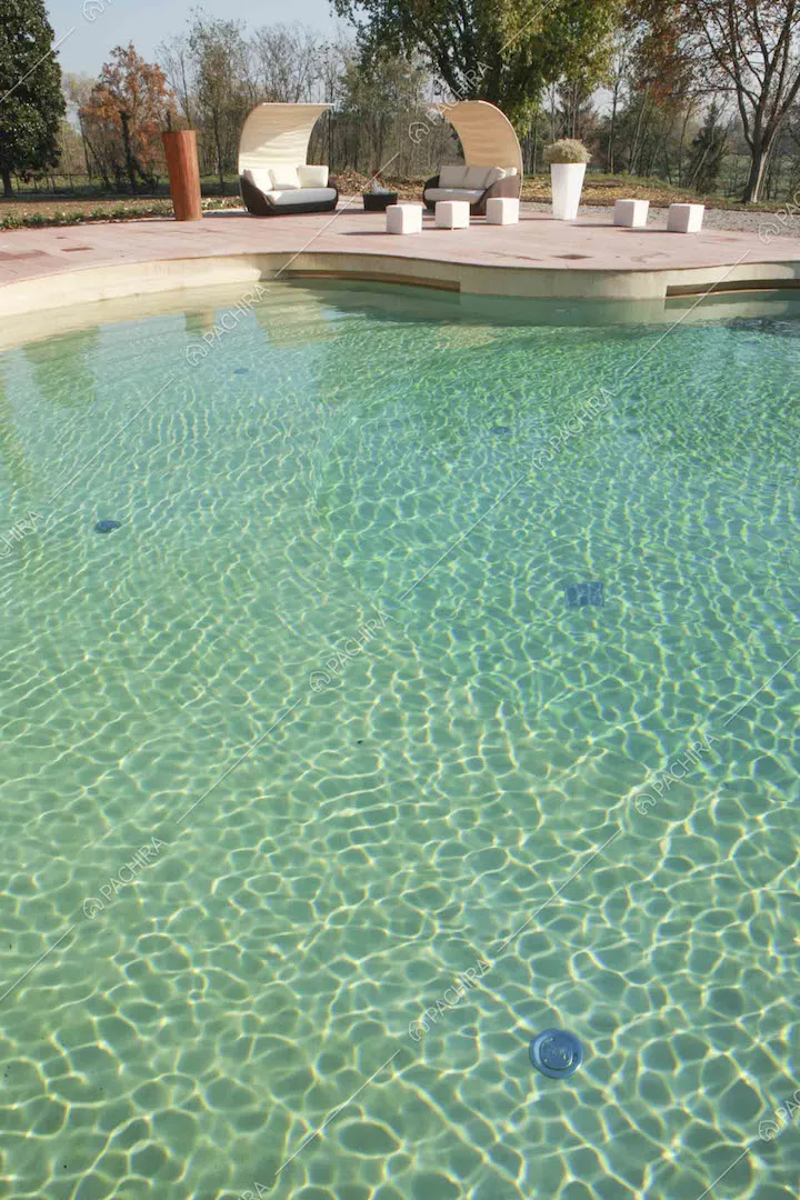 Dalla piscina vista sui divani da esterno e sul parco