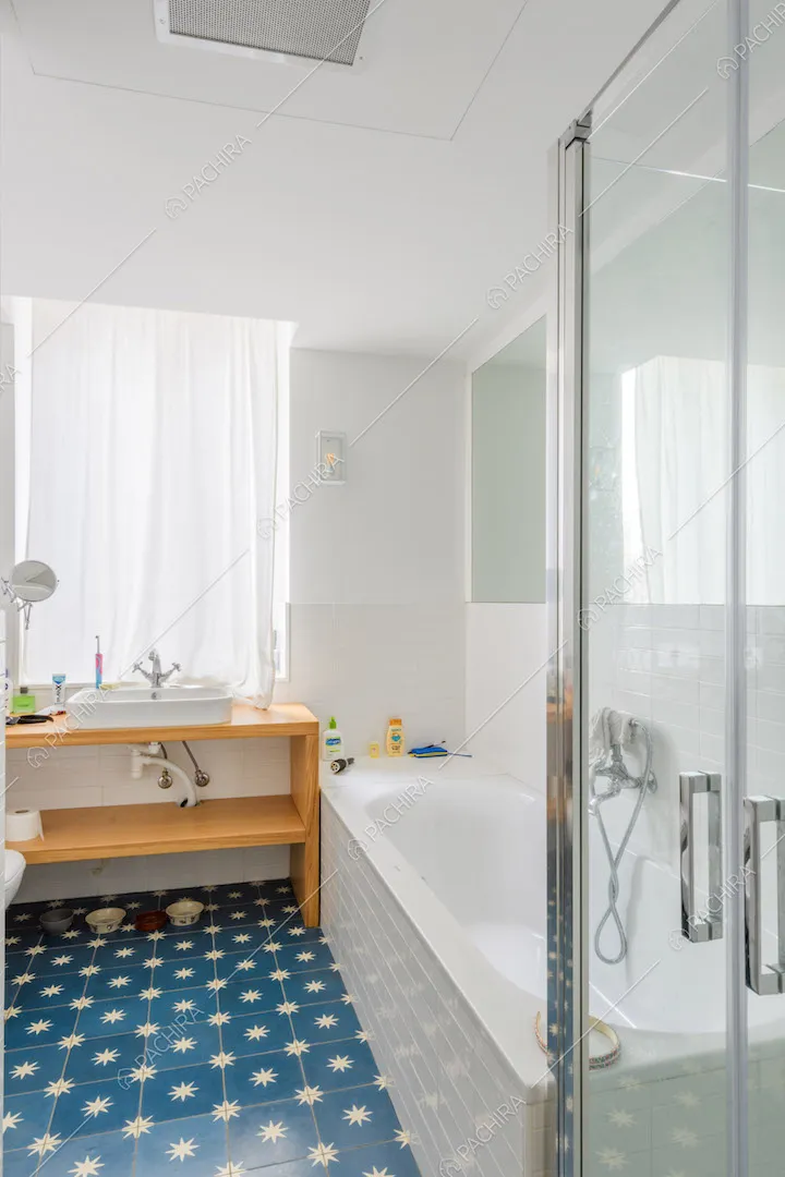 Bagno con vasca, box doccia e pavimento in piastrelle blu con stelle