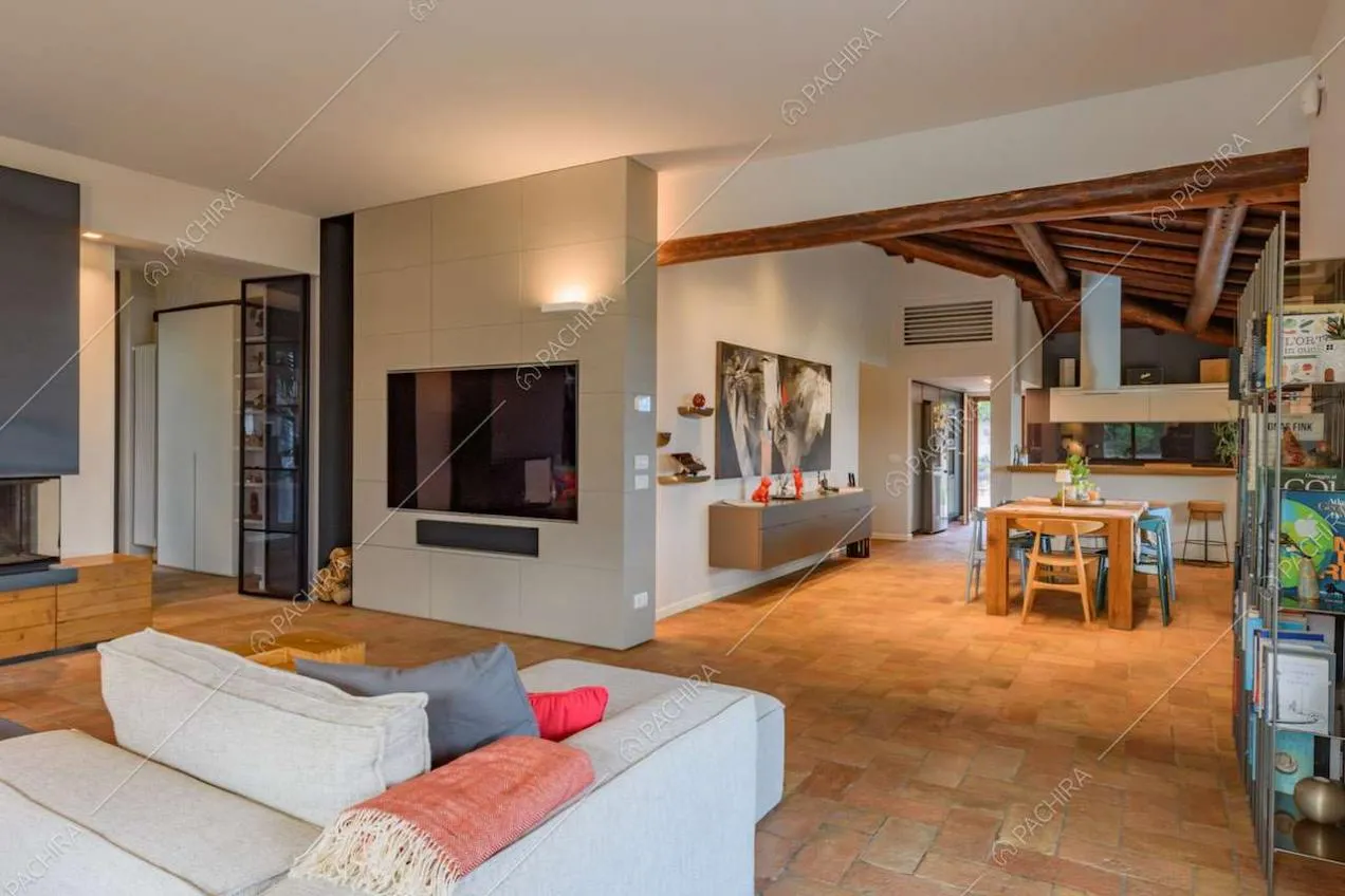 Dal divano del salotto vista sulla sala da pranzo con soffitto in travi in legno