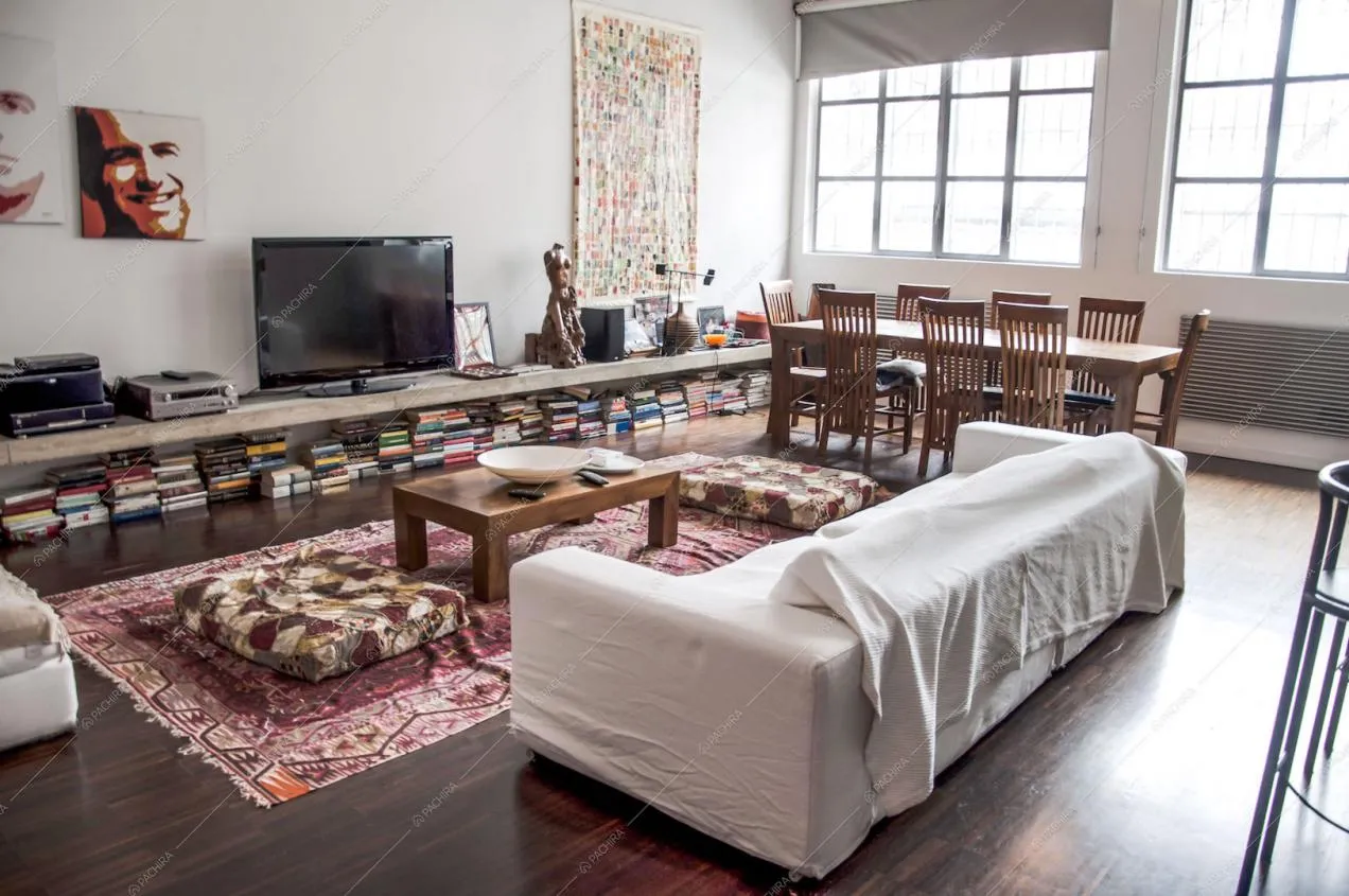 Zona living con divano, tavolo da pranzo e vetrate