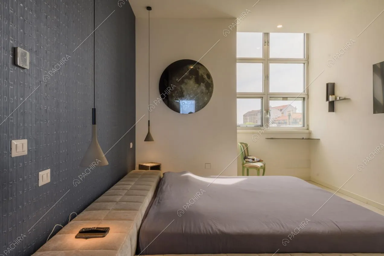 Camera da letto matrimoniale con parete blu e finestra in stile industriale