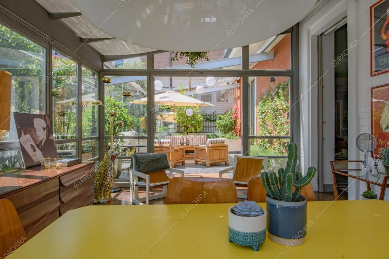 Tavolo da pranzo giallo nella grande veranda sulla terrazza con ombrellone