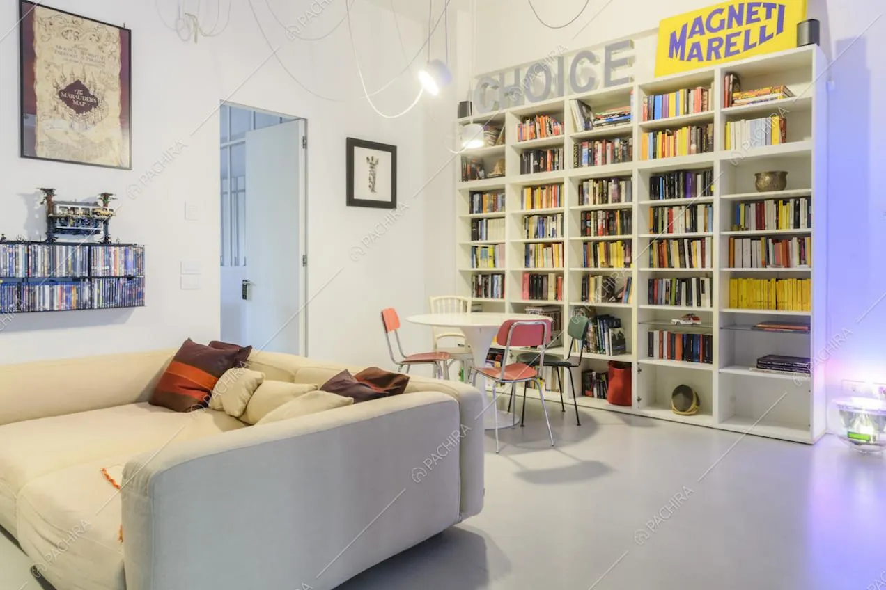 Divano e libreria bianchi in salotto dallo stile contemporaneo
