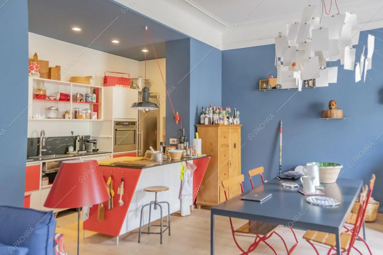 Tavolo da pranzo blu e cucina open space con mobili bianchi e rossi