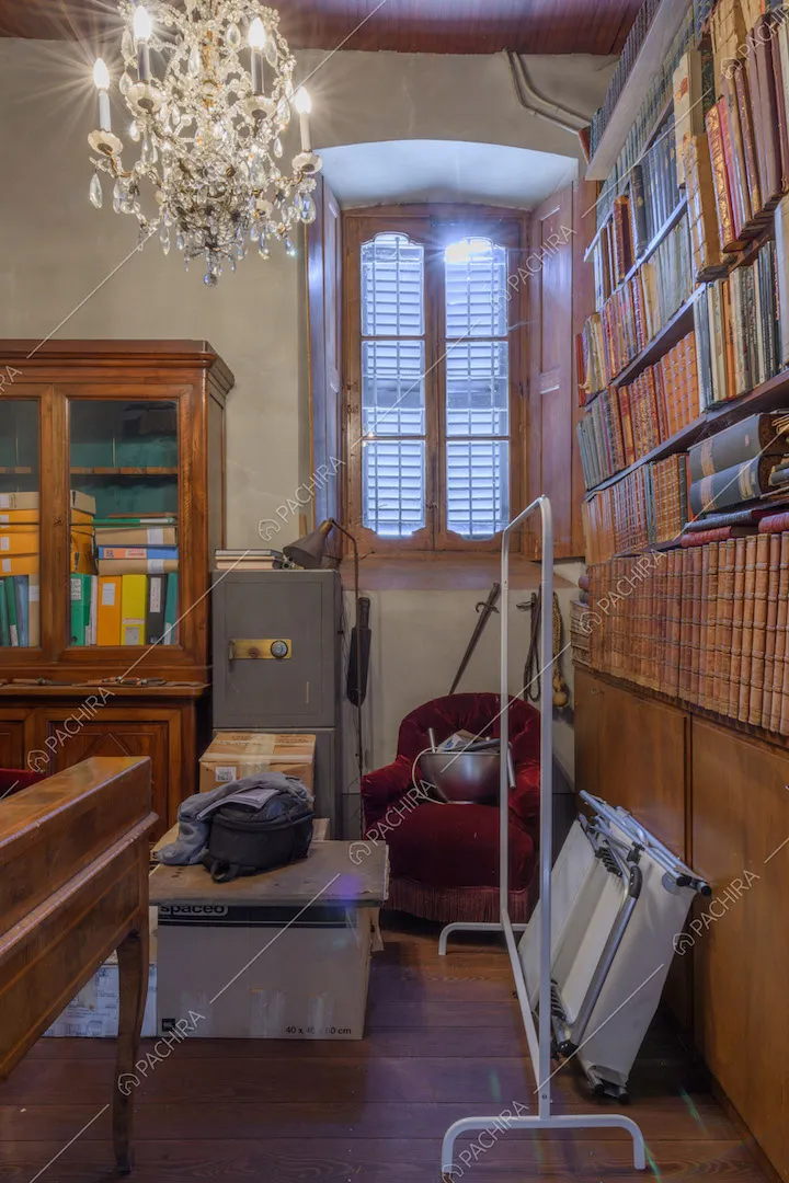 Biblioteca con lampadario in cristallo e pavimento in parquet