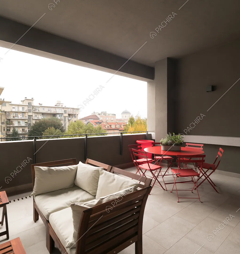 Tavolo da pranzo e sedie in metallo rosso nella loggia