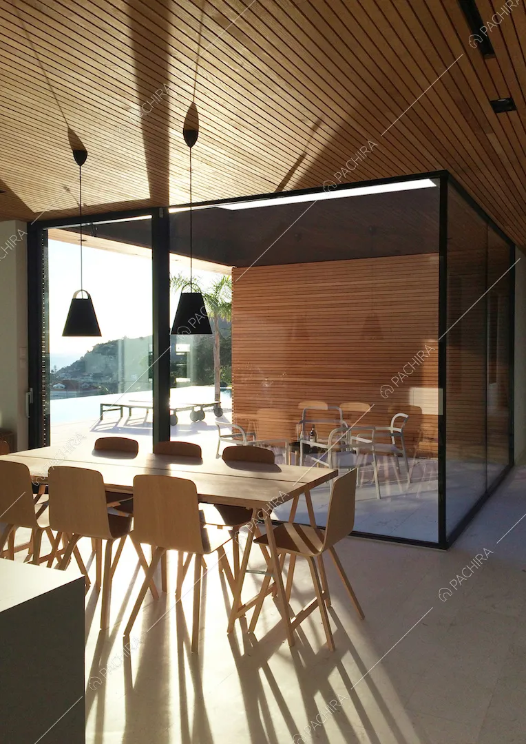 Tavolo da pranzo in legno e vista sulla veranda a cui si accede attraverso la porta-finestra