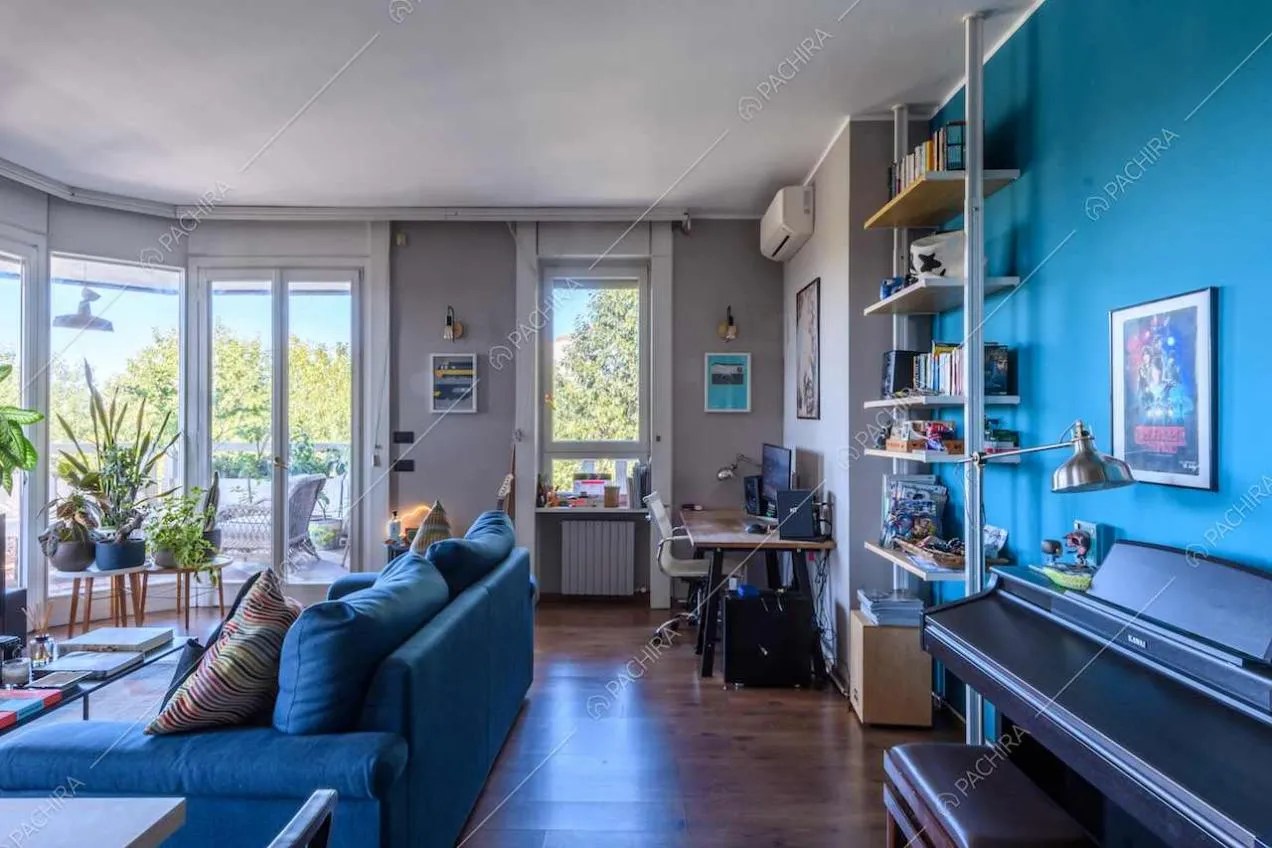 Parete azzurra nella zona living con porte-finestre per accedere alla terrazza