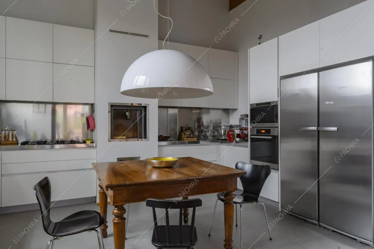 Cucina bianca a parete con tavolo in legno e fornelli a gas