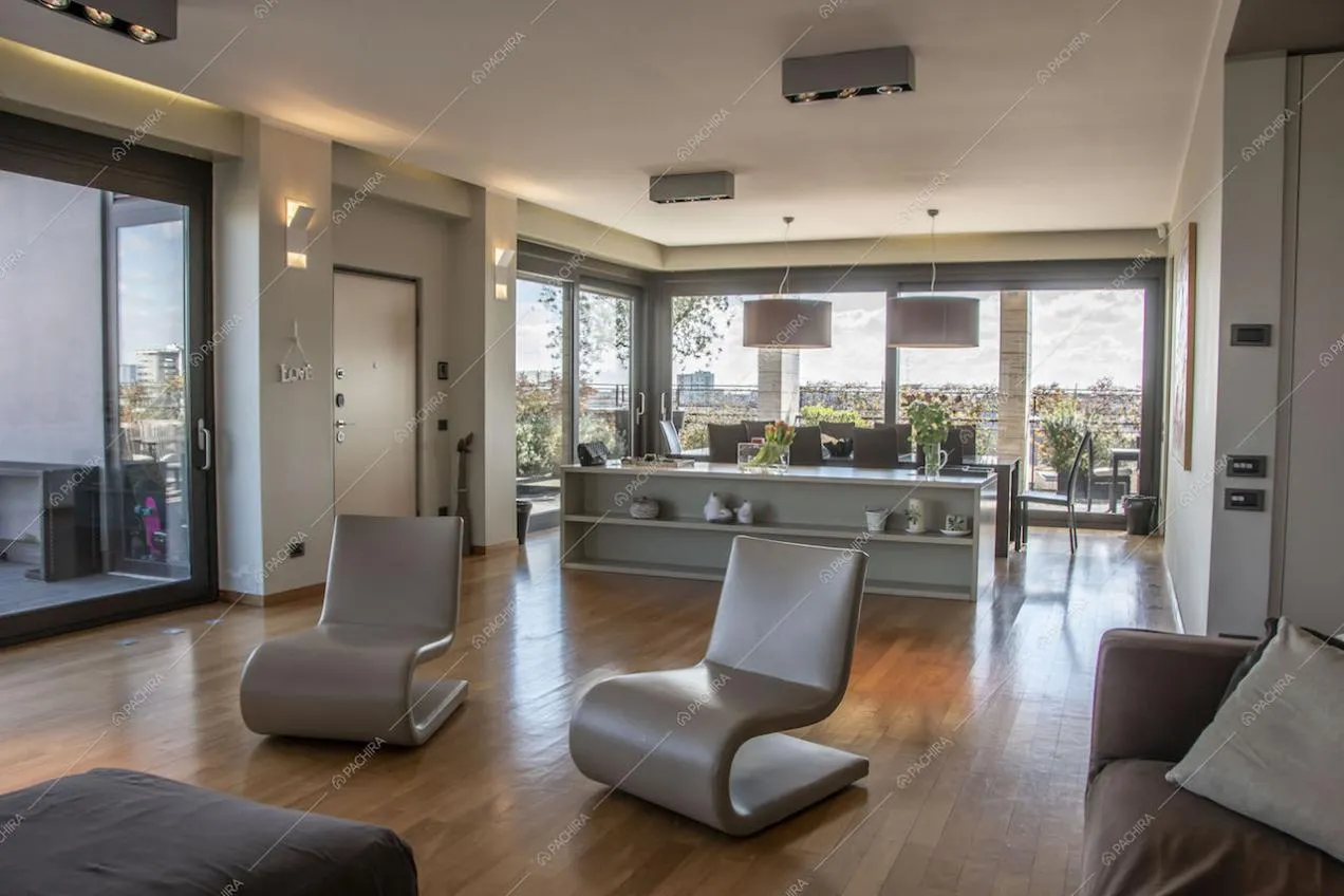 Poltrone di design nel salotto della location e vista panoramica grazie alle ampie vetrate