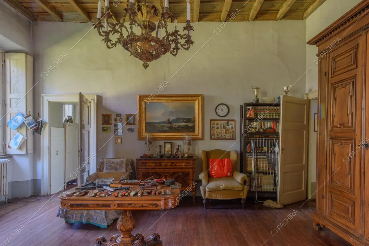Luminosa sala con pavimento in parquet, soffitto a cassettoni e armadio con boiserie