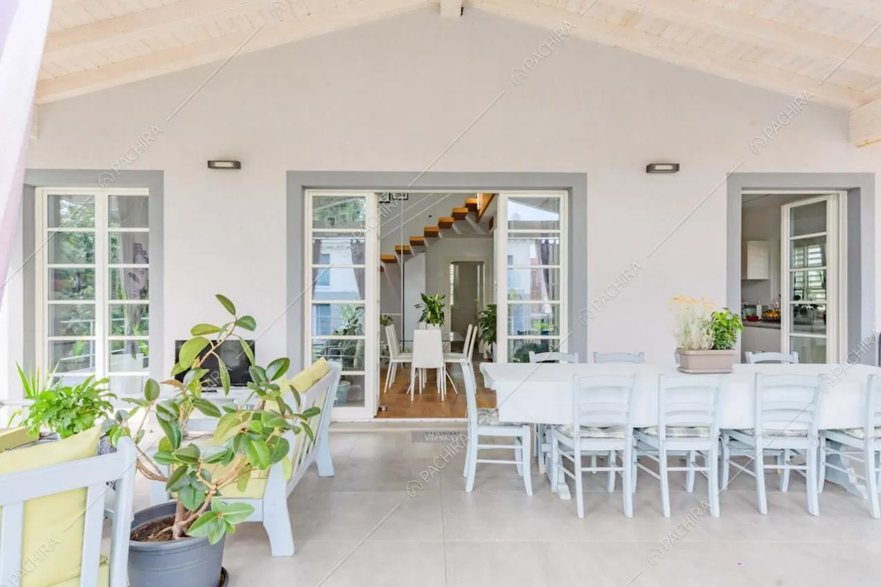 Grande veranda con soffitto in travi in legno e vista sulla zona living