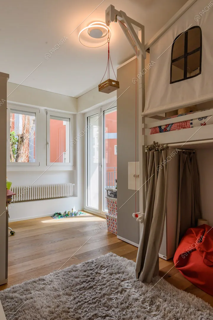 Camera da letto dei bambini con pavimento in parquet e porta-finestra