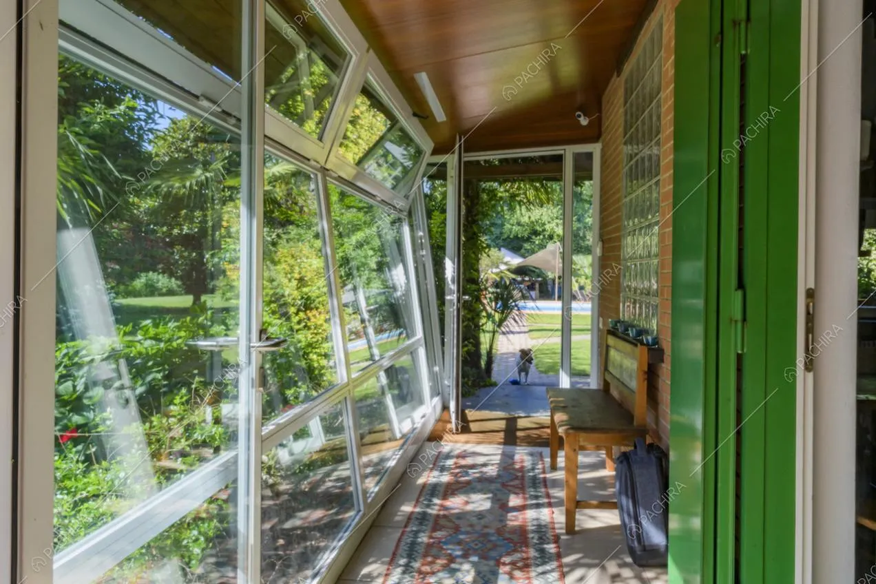 Veranda con pareti in vetro sul fianco della villa