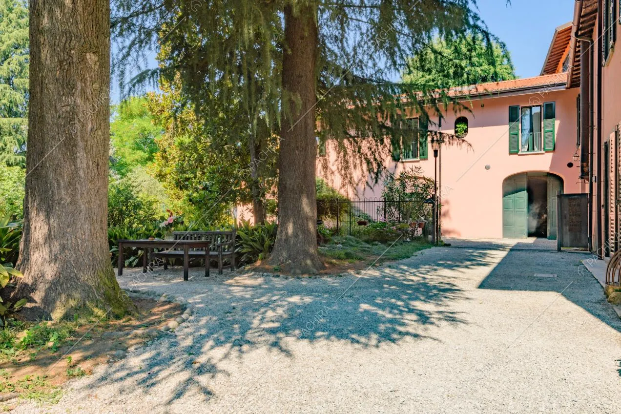 Panchine, grandi alberi ed esterni rosa