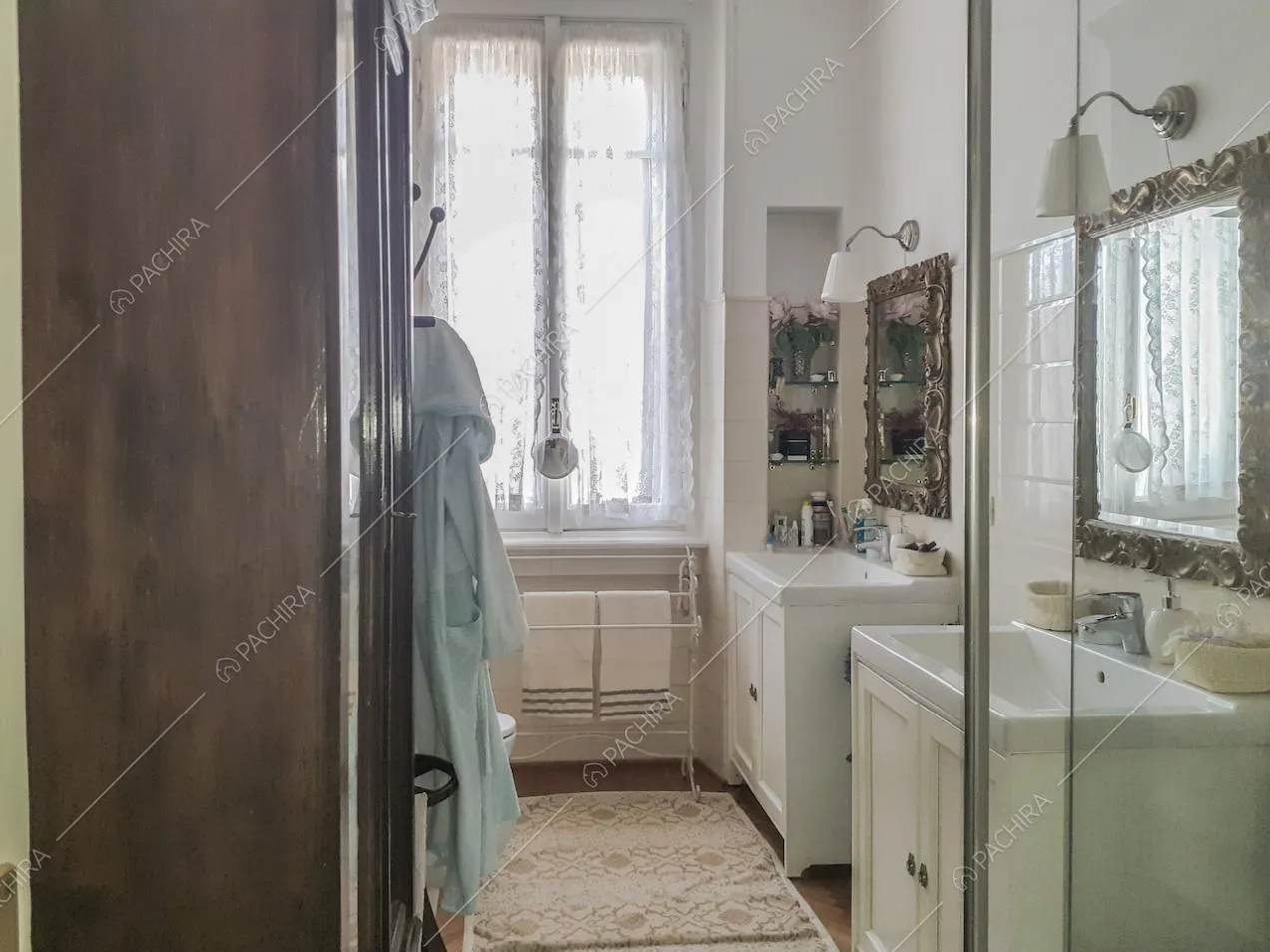 Bagno con due lavandini separati, specchi e lampade da parete