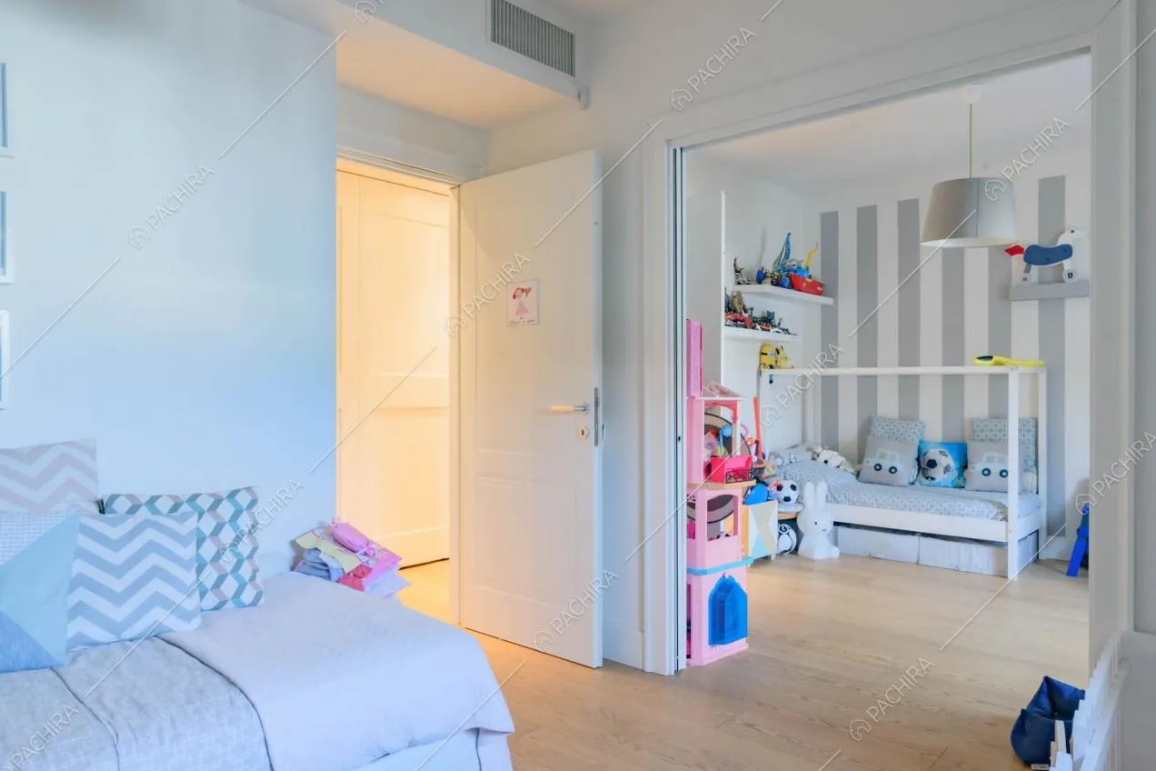 Camere da letto dei bambini comunicanti separati da porte bianche scorrevoli
