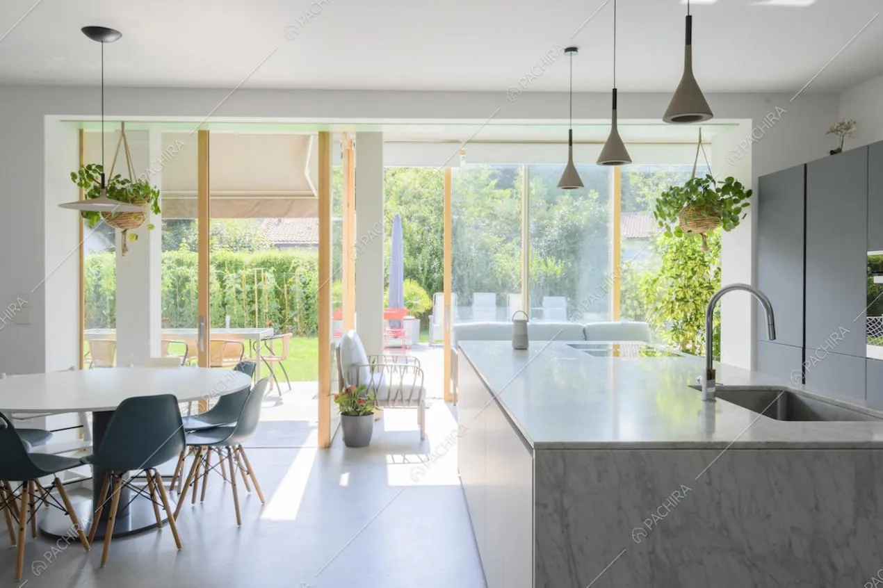 Zona giorno con cucina a vista e grandi vetrate