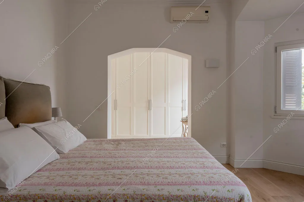 Camera da letto matrimoniale con pareti bianche della villa Pino Mugo, location in stile moderno a Roma