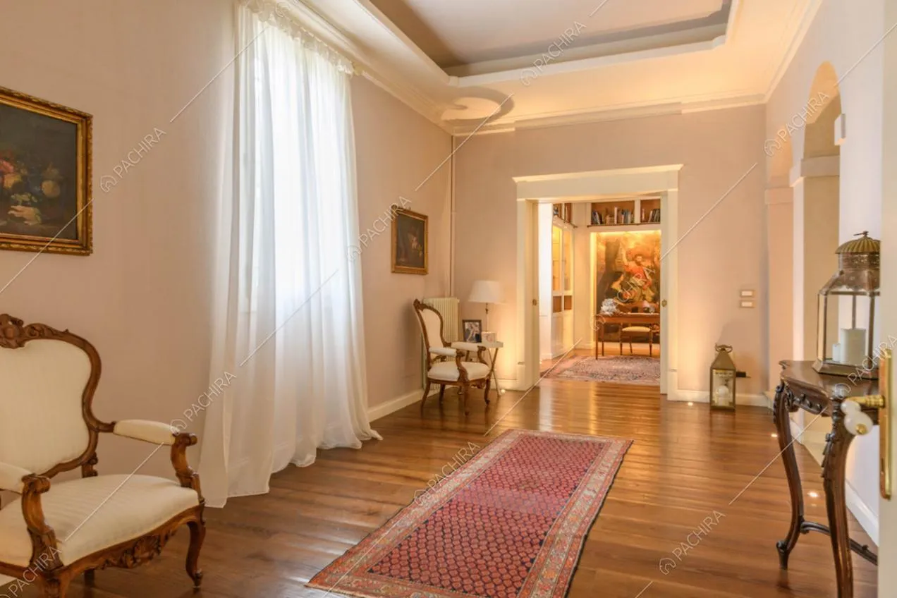 Corridoio con pavimento in parquet, boiserie sul soffitto e vista sulla scrivania