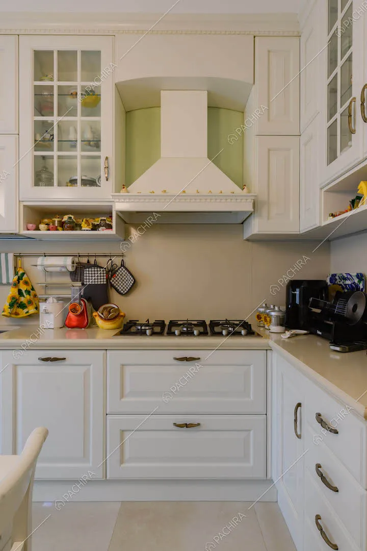 Cucina a parete con fornelli a gas e cassetti bianchi con boiserie