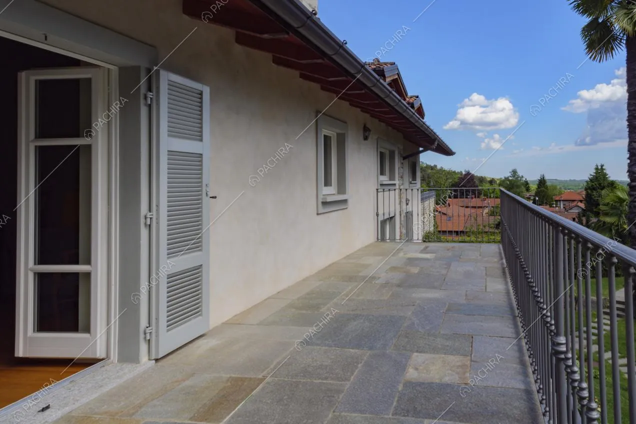 Terrazza con pavimentazione in pietra e vista sul giardino