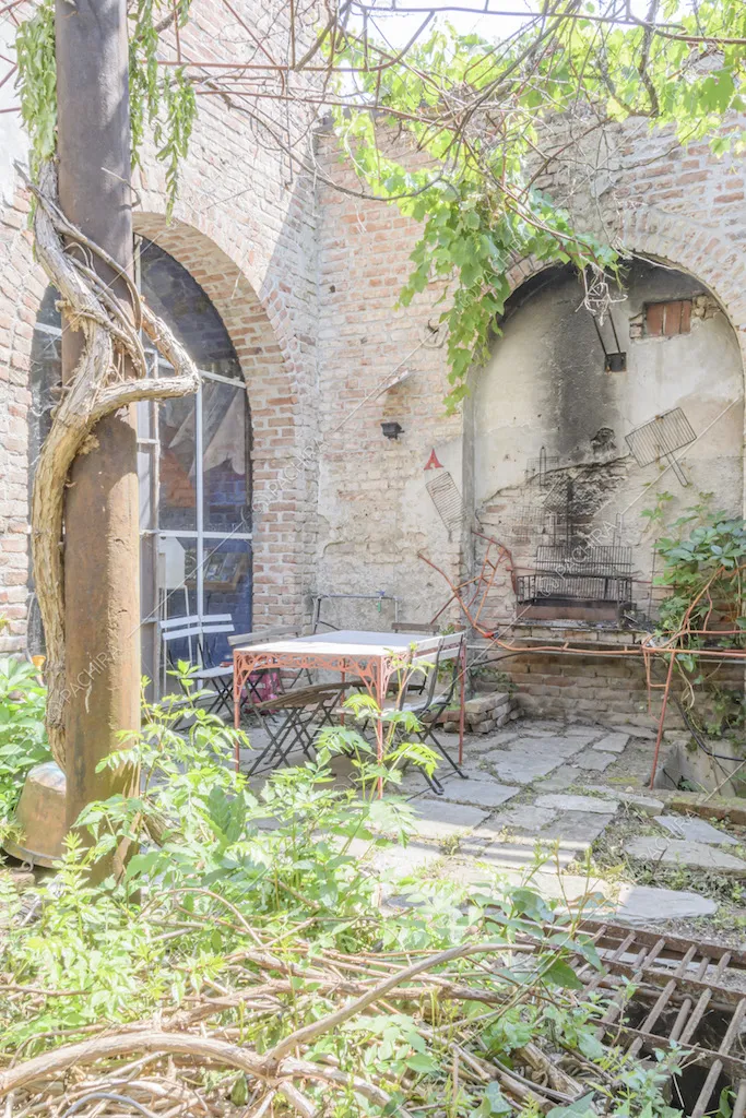 Angolo di cortile con tavolo, sedie e piante