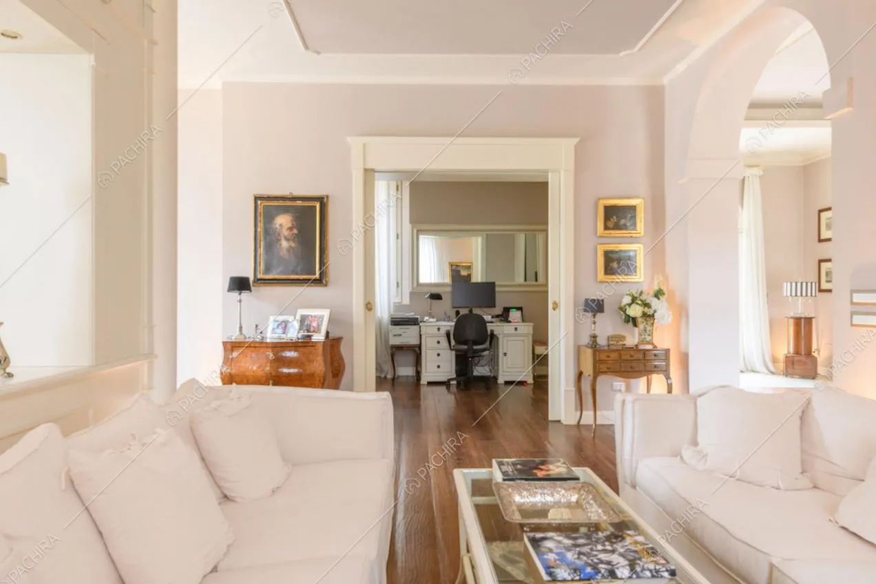 Dai divani bianchi della zona living vista sullo studio con pavimento in parquet