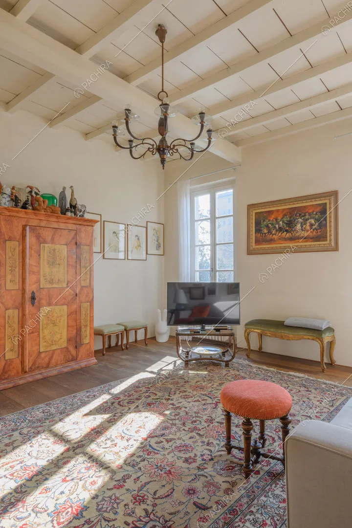 Luminoso salotto con pavimento in parquet, soffitto a cassettoni e grande tappeto