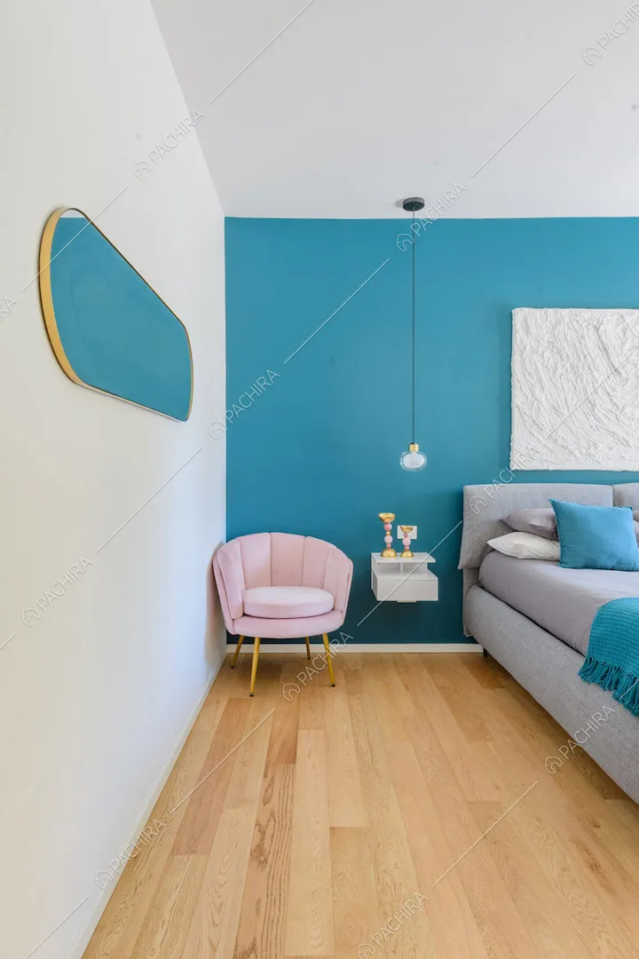Camera da letto matrimoniale con pavimento in parquet e parete azzurra