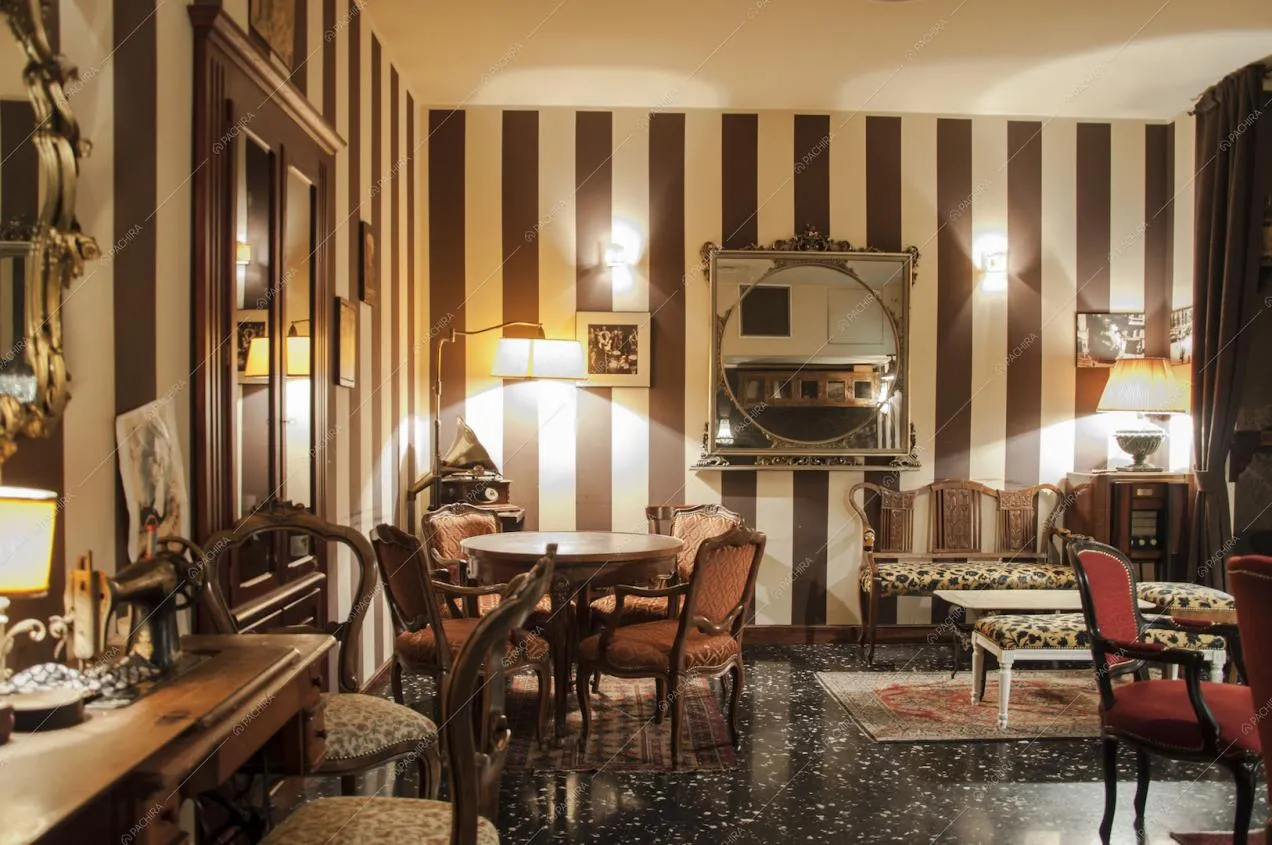 Tavoli e sedie d'epoca, carta da parati a strisce bianche e marroni