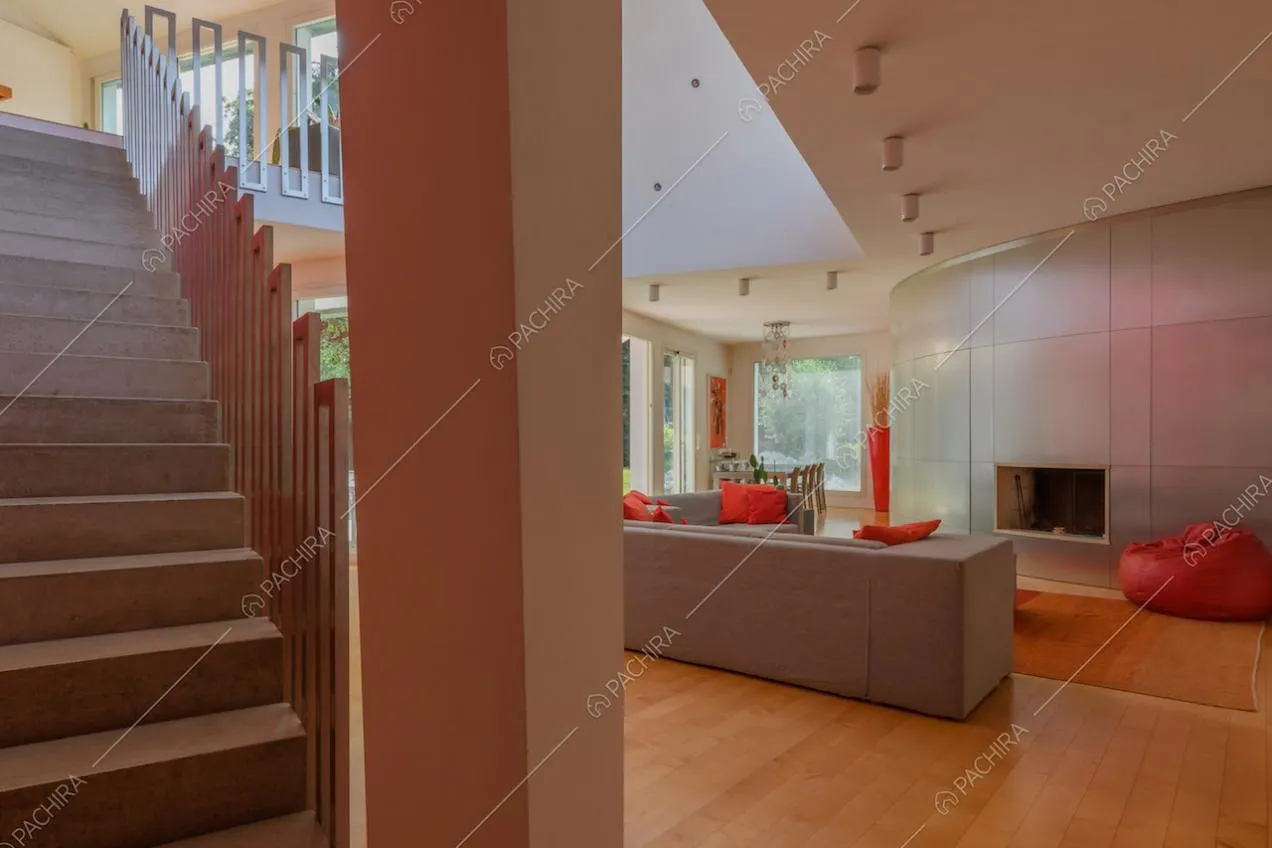 Scale nella zona living con pavimento in parquet e camino