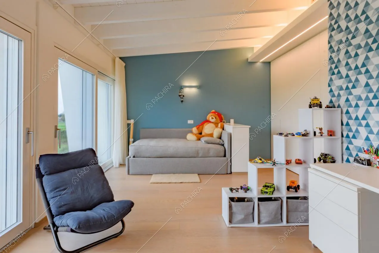 Camera da letto con parete azzurra, travi bianche a vista sul soffitto e pavimento in parquet