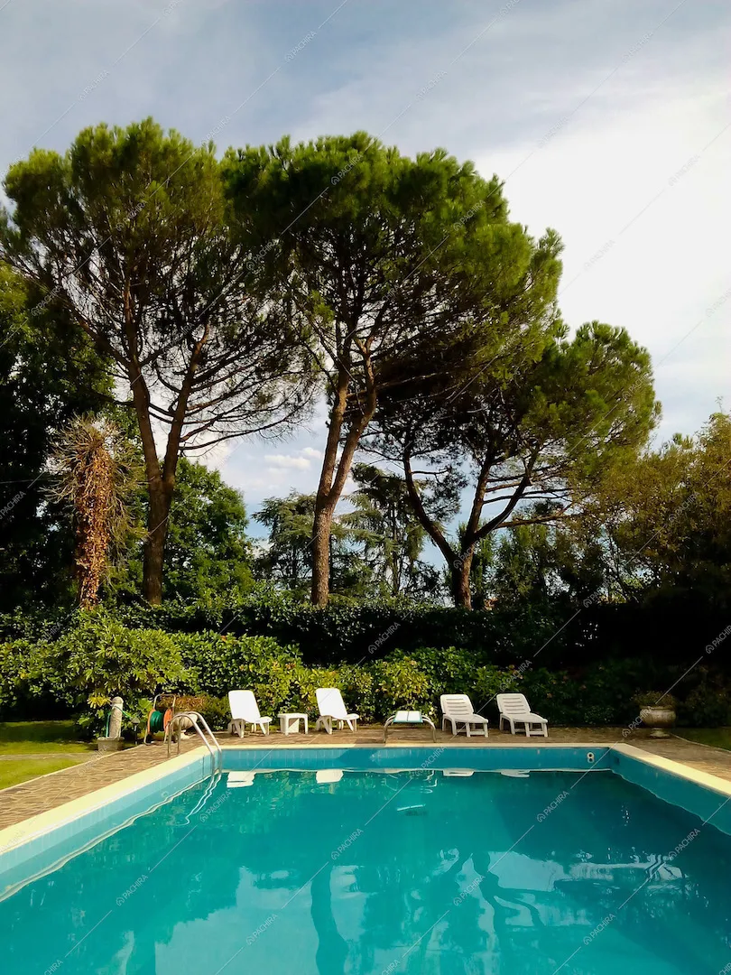 La grande piscina con sedie a sdraio