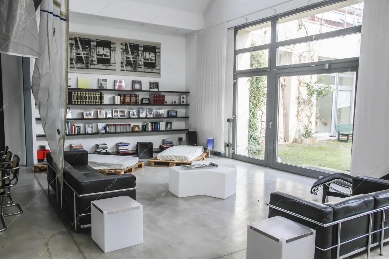 Zona living con divani neri in pelle e vetrate