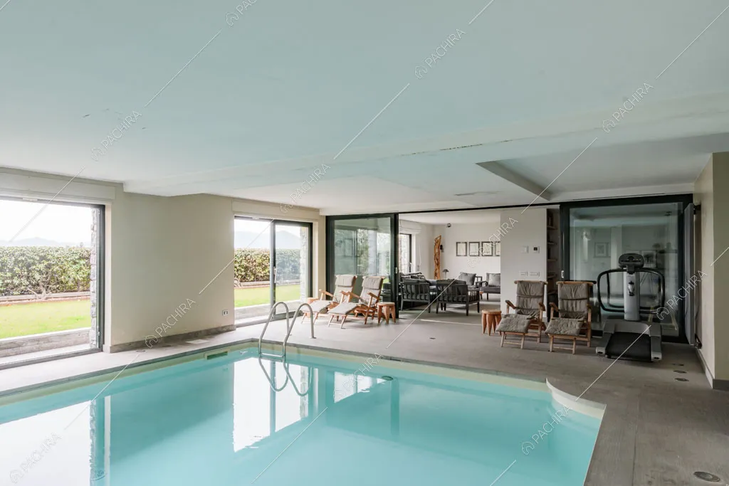 Vista sul giardino dalla piscina interna della villa Roveja, location in stile contemporaneo a Como