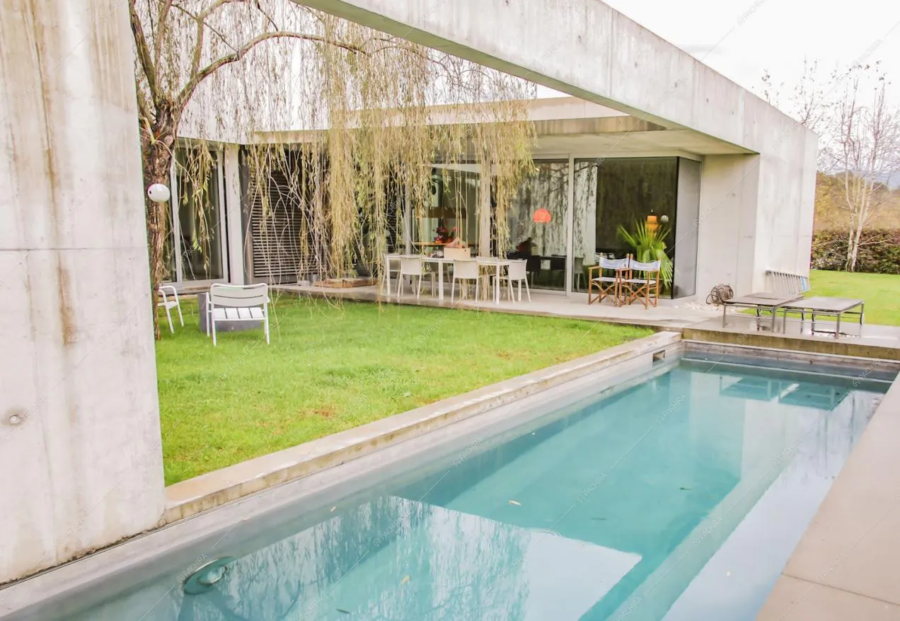 Piscina con sdraio e tavolo da pranzo